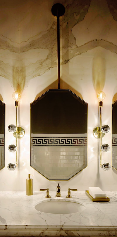 An art-deco style bathroom with gold trim
